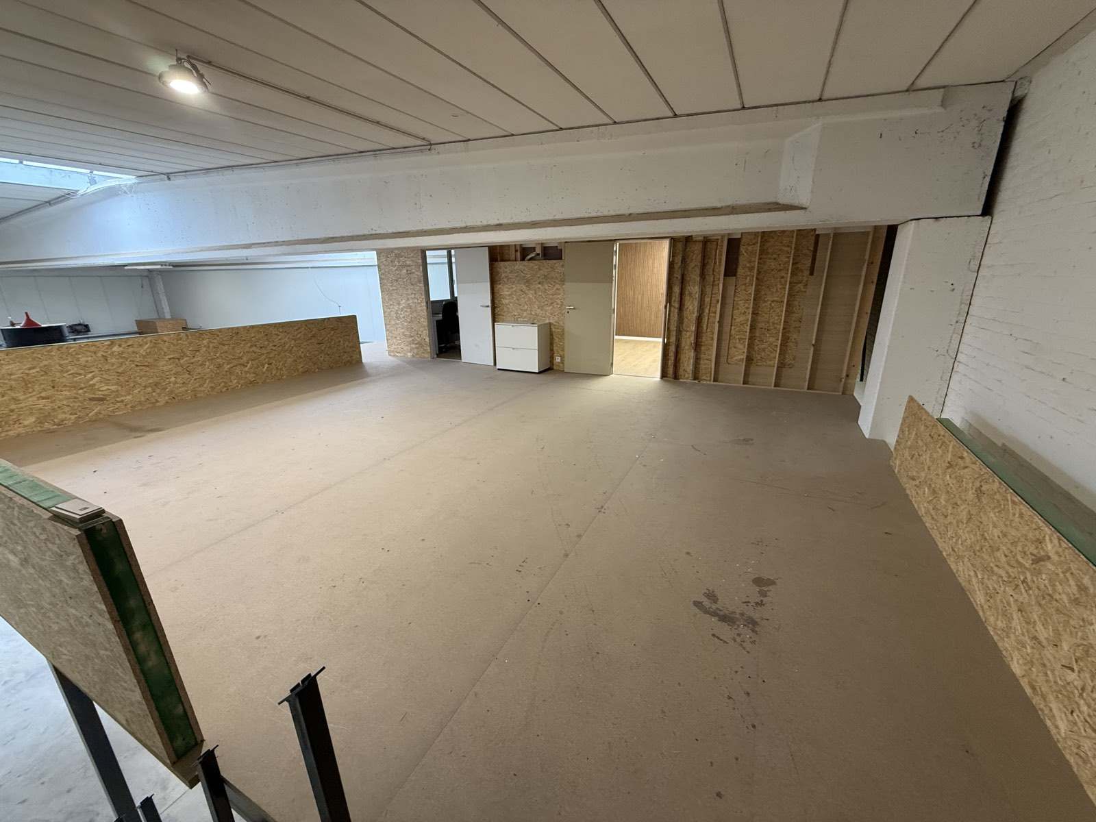 Tussenverdieping met witte balken en OSB-balustrade
